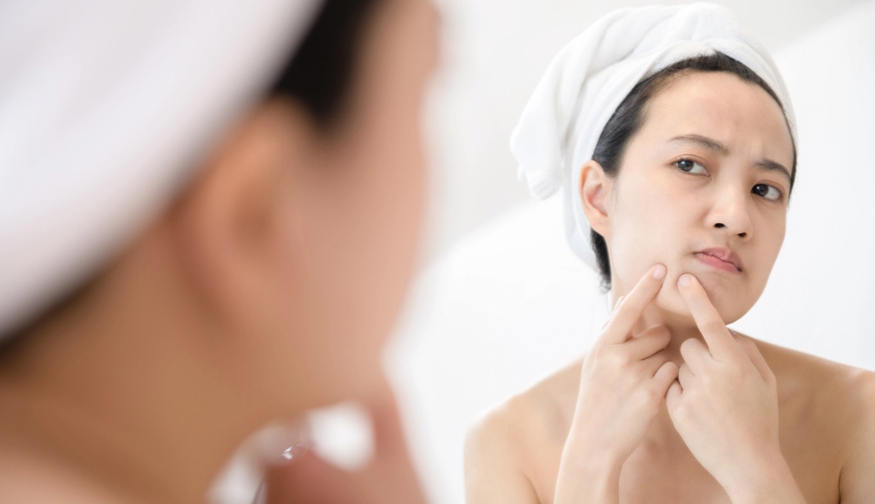 problem skin concerned young asian women popping pimple cheek while standing near mirror bathroom young asian women wi